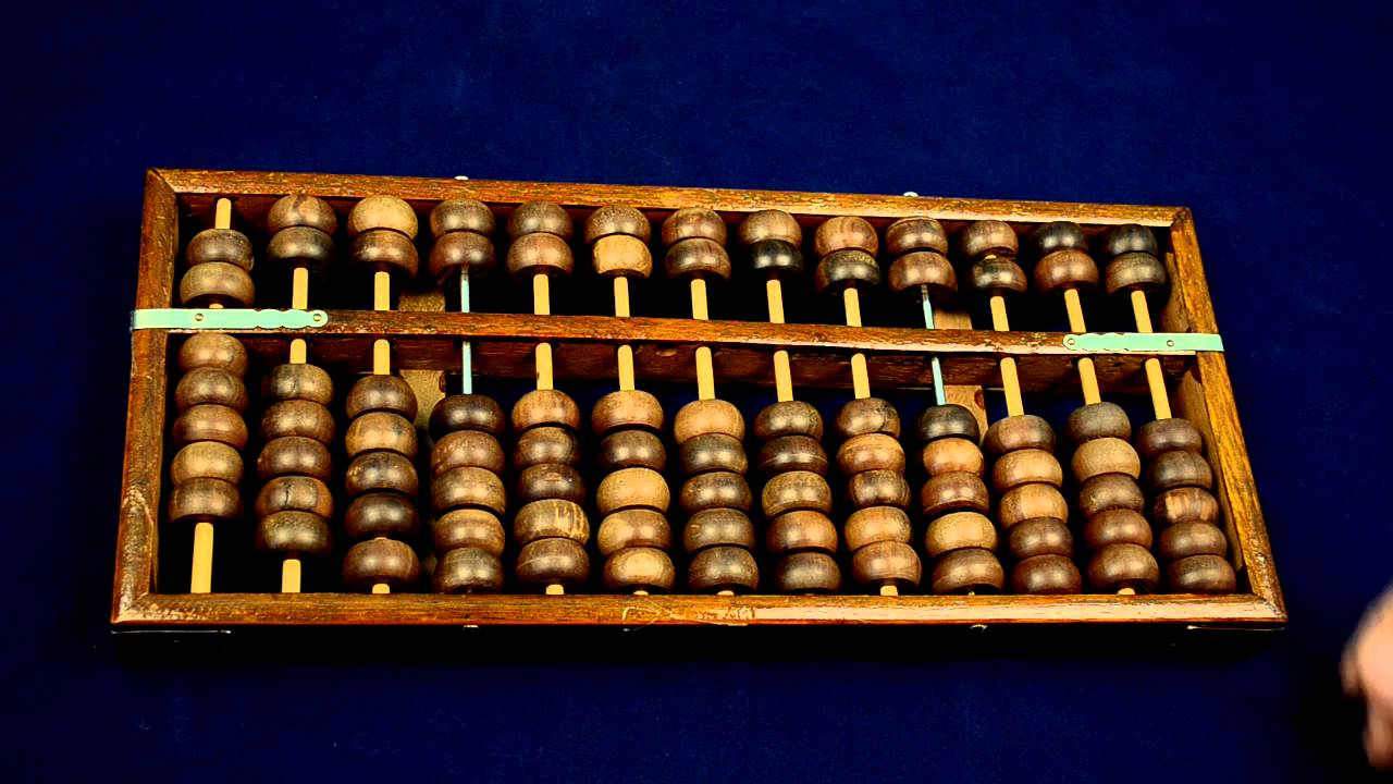 Traditional wooden abacus with beads slid to one side on a dark blue background | Guci Image